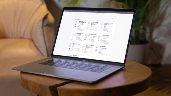 Laptop på ett bord visar Munskänkarnas webbsida med evenemang och vinprovningar listade.