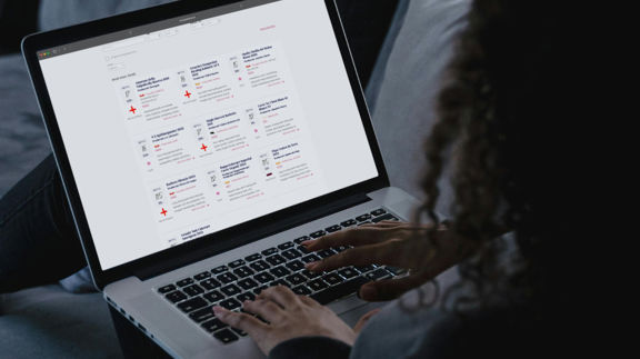 Person sitter i en soffa och använder en laptop med Munskänkarnas webbplats öppen.